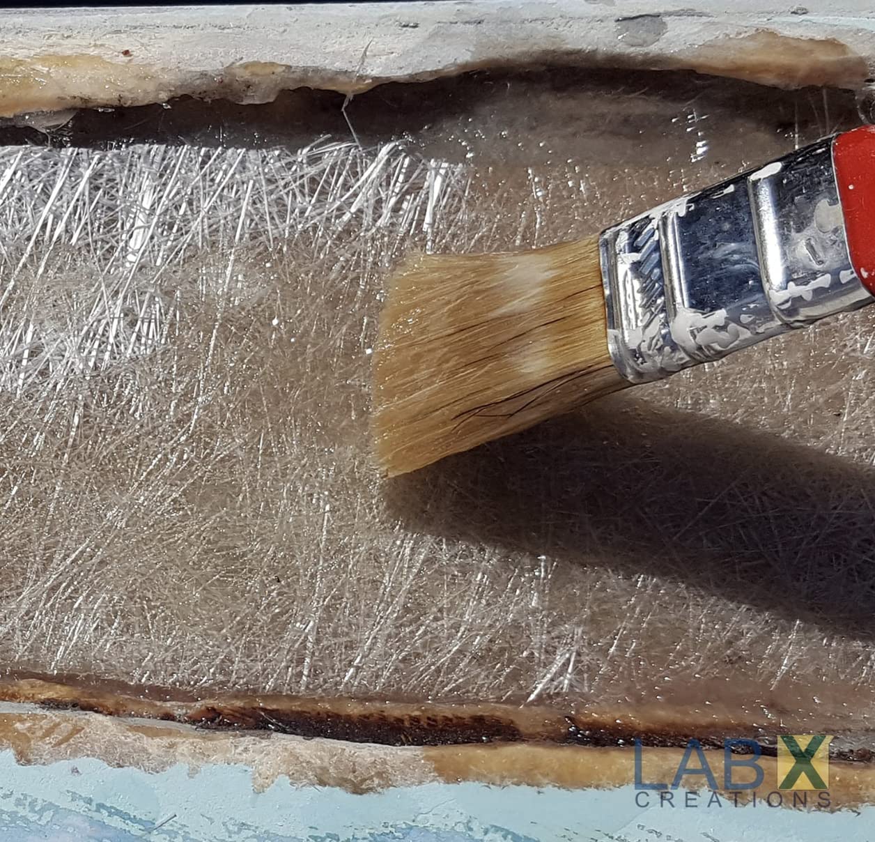 Brush applying a resin to a textured surface with 'LAB X Creations' branding.